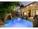 Night view of backyard pool with rock waterfall, spa and patio area at 3603 E Indigo Bay Ct, Gilbert, AZ 85234