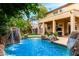 Backyard pool with rock waterfall, patio, and lush landscaping offering a private retreat at 3603 E Indigo Bay Ct, Gilbert, AZ 85234