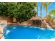 Inviting pool featuring a rock waterfall feature and vibrant blue tile accents at 3603 E Indigo Bay Ct, Gilbert, AZ 85234