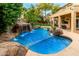 Beautiful backyard pool with rock waterfall, mature trees and adjacent patio for entertaining at 3603 E Indigo Bay Ct, Gilbert, AZ 85234