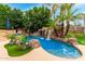 A beautiful backyard swimming pool with a waterfall feature and lush landscaping at 3603 E Indigo Bay Ct, Gilbert, AZ 85234