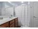 Well-lit bathroom features a vanity with sink, mirror, and a shower-tub combination with a decorative curtain at 38208 N La Grange Ln, San Tan Valley, AZ 85140