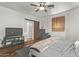 Bedroom with wood-look floors, ceiling fan, and ensuite bathroom with barn door at 38208 N La Grange Ln, San Tan Valley, AZ 85140