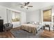 Bedroom with wood floors, ceiling fan, window with blinds, and sitting chair at 38208 N La Grange Ln, San Tan Valley, AZ 85140