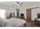 Bedroom featuring wood-look floors, ceiling fan, and ensuite bathroom with barn door at 38208 N La Grange Ln, San Tan Valley, AZ 85140