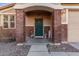 Charming front entrance features a decorative brick surround and a lovely green door at 38208 N La Grange Ln, San Tan Valley, AZ 85140