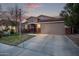 Inviting single-story home with a two-car garage, landscaped front yard, and a picturesque evening sky at 38208 N La Grange Ln, San Tan Valley, AZ 85140