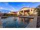 Backyard pool with a red umbrella, covered patio, and desert landscaping, perfect for enjoying outdoor living at 38208 N La Grange Ln, San Tan Valley, AZ 85140