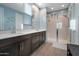 Bathroom with a dual sink vanity, large mirror, and glass-enclosed shower with tile surround at 4143 E Appaloosa Rd, Gilbert, AZ 85296