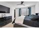 Bedroom featuring a dark wood dresser, TV, ceiling fan, and a large window at 4143 E Appaloosa Rd, Gilbert, AZ 85296