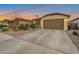 Attractive home with a two-car garage, xeriscaping, and dusk lighting, enhancing its curb appeal at 4143 E Appaloosa Rd, Gilbert, AZ 85296