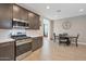 A modern kitchen with stainless steel appliances flows into the dining area with a round table at 4143 E Appaloosa Rd, Gilbert, AZ 85296