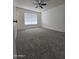 A standard-sized bedroom with carpet, window, ceiling fan, and neutral wall color at 4601 E Pollack Ln, Phoenix, AZ 85042