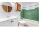 Bathroom with green tile, white fixtures, and wood accents at 4626 W Mitchell Dr, Phoenix, AZ 85031