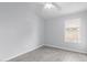 Empty bedroom with sleek gray wood-grain flooring and natural light from a window at 5145 W Tonto Rd, Glendale, AZ 85308