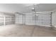 Spacious garage with two overhead doors, shelving, and concrete flooring at 5145 W Tonto Rd, Glendale, AZ 85308