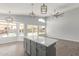 Open kitchen features a marble island, pendant lighting, and multiple windows with a pool view at 5145 W Tonto Rd, Glendale, AZ 85308