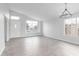 Bright, open-concept living room featuring tile floors, plenty of natural light, and a contemporary chandelier at 5145 W Tonto Rd, Glendale, AZ 85308