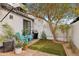 Charming backyard with artificial turf, mature tree, string lights, and turquoise Adirondack chairs at 5326 N 3Rd Ave, Phoenix, AZ 85013