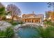 An expansive backyard with a pool, waterfall, patio, and palm trees at 5433 E Nisbet Rd, Scottsdale, AZ 85254