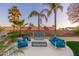 Comfortable outdoor seating area with sleek chairs and cushions surrounded by mature palm trees and desert landscaping at 5433 E Nisbet Rd, Scottsdale, AZ 85254