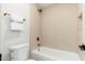 Tiled tub and shower with bronze fixtures, white toilet, and white towel at 5433 E Nisbet Rd, Scottsdale, AZ 85254