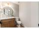 Charming powder room featuring a stylish round mirror and a wood vanity at 5433 E Nisbet Rd, Scottsdale, AZ 85254