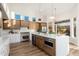 Modern kitchen with stainless steel appliances, a large island, and wood floors at 5433 E Nisbet Rd, Scottsdale, AZ 85254