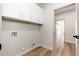 Clean laundry room with white cabinets, gold hardware, and wood-look flooring at 5433 E Nisbet Rd, Scottsdale, AZ 85254