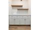 Well-organized laundry room with white cabinets, marble countertop, and wooden floating shelves at 5433 E Nisbet Rd, Scottsdale, AZ 85254