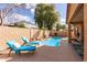 Serene backyard featuring a sparkling pool with lounge chairs and desert landscaping at 545 N Bluejay Dr, Gilbert, AZ 85234