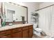 Bathroom featuring a granite countertop, wood cabinets, a large mirror, and a shower with a curtain at 545 N Bluejay Dr, Gilbert, AZ 85234