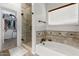 Bright bathroom featuring a soaking tub, a glass-enclosed shower, and a view of the walk-in closet at 545 N Bluejay Dr, Gilbert, AZ 85234