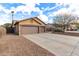 Spacious three-car garage with a long driveway and desert landscaping in the front yard at 545 N Bluejay Dr, Gilbert, AZ 85234