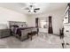 Spacious main bedroom featuring plush carpeting, a ceiling fan, and a large window with elegant curtains at 545 N Bluejay Dr, Gilbert, AZ 85234