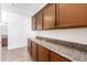 Pantry with granite countertops, wood cabinets, tile flooring, and ample storage space at 545 N Bluejay Dr, Gilbert, AZ 85234