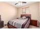 Cozy bedroom featuring a ceiling fan, a window with blinds, and a comfortable bed with a stylish patterned cover at 6009 W Questa Dr, Glendale, AZ 85310