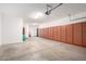 Spacious garage featuring a row of storage cabinets, good lighting, and a clean concrete floor at 6009 W Questa Dr, Glendale, AZ 85310