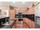 Modern kitchen with stainless steel appliances, wood cabinets and black countertops at 6009 W Questa Dr, Glendale, AZ 85310