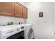 Functional laundry room with modern appliances, wood cabinets, and a clean, well-lit space at 6009 W Questa Dr, Glendale, AZ 85310