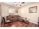 Comfortable living room featuring a brown sofa, wood floors, and natural light at 6009 W Questa Dr, Glendale, AZ 85310