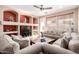 Inviting living room featuring a ceiling fan, decorative shelving, and comfortable sofas at 6009 W Questa Dr, Glendale, AZ 85310