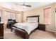 Comfortable main bedroom featuring a ceiling fan, desk, and a large window at 6009 W Questa Dr, Glendale, AZ 85310