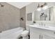 Updated bathroom featuring a tiled shower-tub, a large vanity, and modern fixtures at 601 W Yukon Dr # 1, Phoenix, AZ 85027