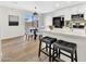 Bright kitchen with white cabinets, an island with bar stools, and a view of the adjacent dining area with sliding doors at 601 W Yukon Dr # 1, Phoenix, AZ 85027