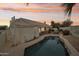 Backyard with in-ground pool, spiral staircase, covered patio and lush landscaping viewed at twilight at 6460 E Trailridge Cir # 2, Mesa, AZ 85215