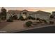 Inviting single-story home at dusk featuring desert landscaping, circular driveway and attached two-car garage at 6460 E Trailridge Cir # 2, Mesa, AZ 85215