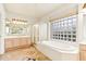 Bright bathroom featuring a soaking tub, glass block window, and vanity at 6460 E Trailridge Cir # 2, Mesa, AZ 85215