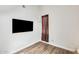 A minimalist bedroom with a mounted TV and wood-look flooring at 6533 N 7Th Ave # 22, Phoenix, AZ 85013