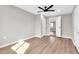 Bedroom with ceiling fan features neutral paint, wood-look floors and closet at 7113 E Bell Cir, Mesa, AZ 85208